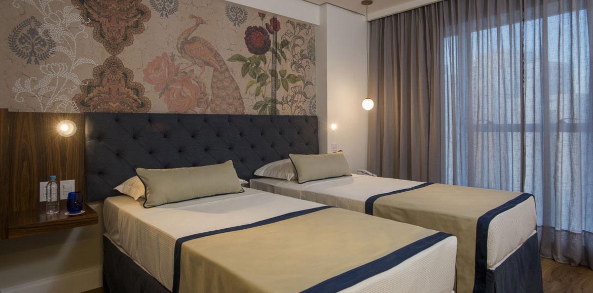 Hotel Luzeiros Recife Exteriér fotografie The photo shows a modern bedroom featuring two single beds that are neatly made with light-colored blankets and decorative pillows. The headboard of the beds is upholstered in a dark material, giving it a stylish appearance. Behind the beds, there is